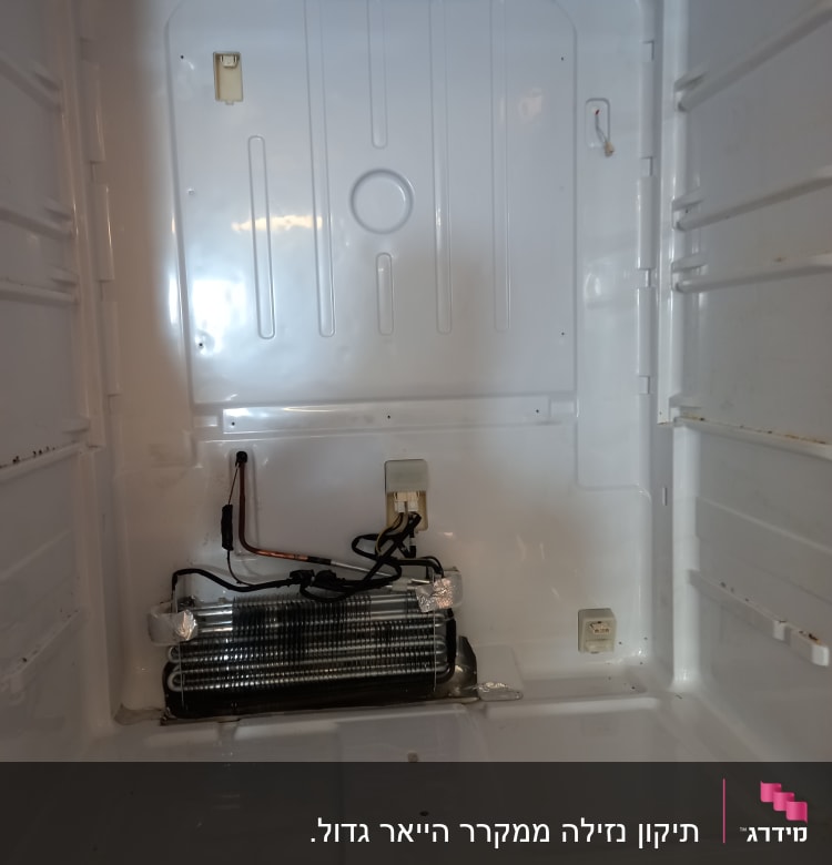 סליל קירור ומאוורר בתוך מקרר פתוח